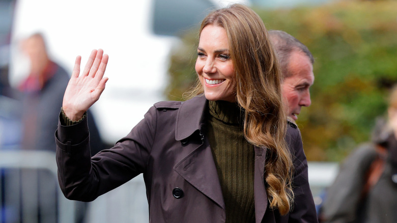Kate Middleton wearing a brown trench coat while waving to people in September 2026