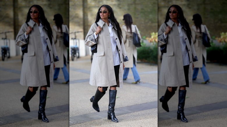 A woman wearing a beige trench and black leather boots