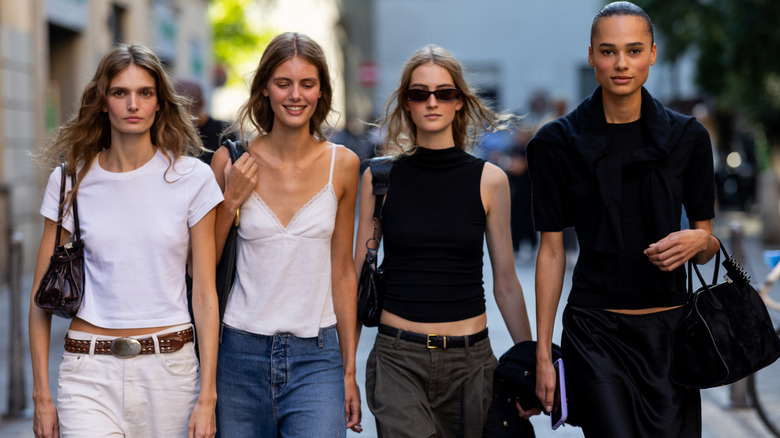 Models wearing basics, including a white tee, a cami, a high-neck tank, and a black tee