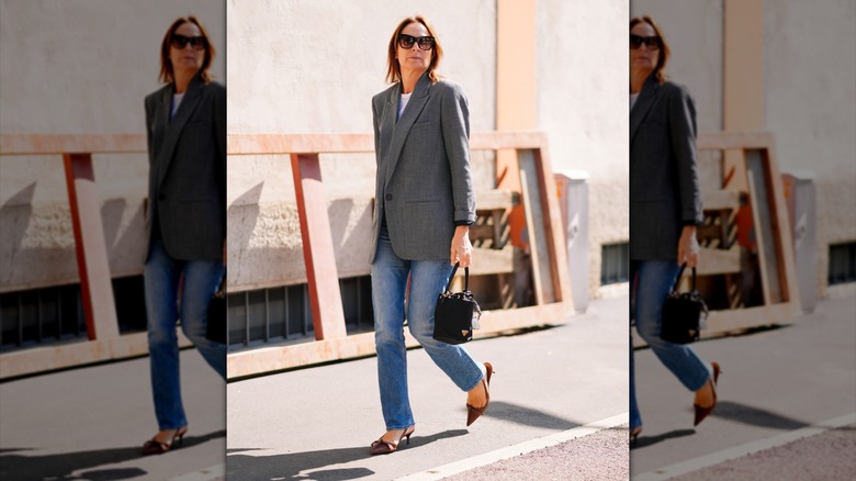 A woman wearing straight leg jeans and a tweed blazer