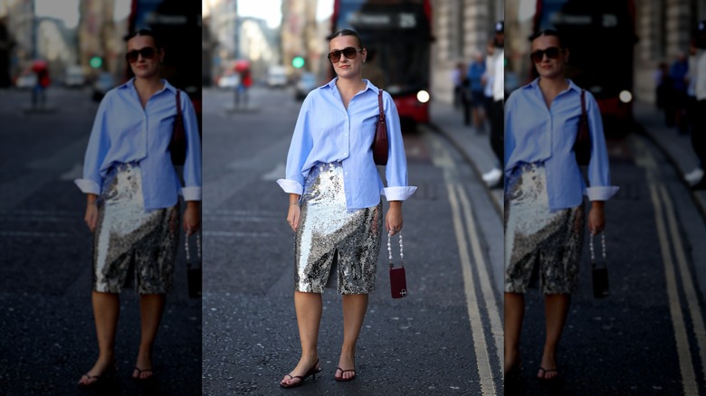 A woman wearing a blue cotton shirt with a sequin skirt