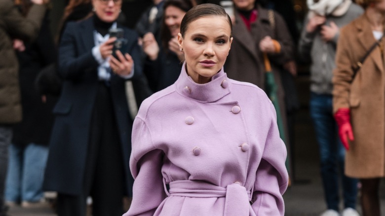 A guest in a lavender purple pea coat during Paris Fashion Week in March 2024