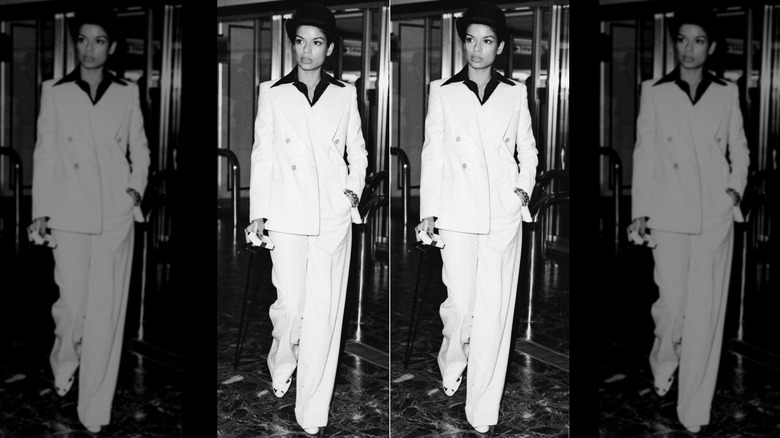 Bianca Jagger posing in a white suit at Heathrow Airport in 1972.