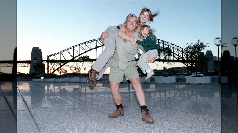 Steve Irwin holding Terri Irwin and Bindi Irwin in front of the Sydney Harbour Bridge