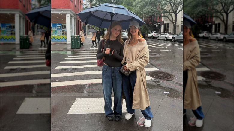 Jessica Alba posing outside in the rain with her daughter Haven holding an umbrella.