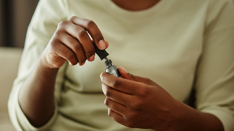 woman closing nail polish bottle