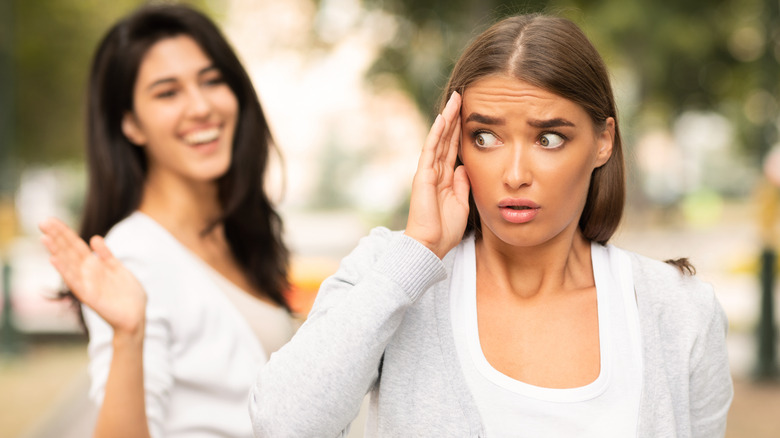 Woman avoiding her friend in the street