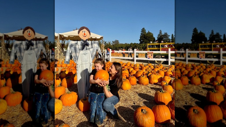 Bindi Irwin cuddling with her daughter Grace in a pumpkin patch