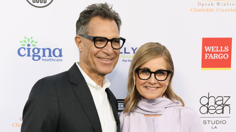 Michael Cummings and Maureen McCormick smile at a red carpet