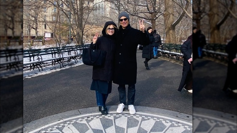 Maureen McCormick and Michael Cummings hold peace signs in the air outside