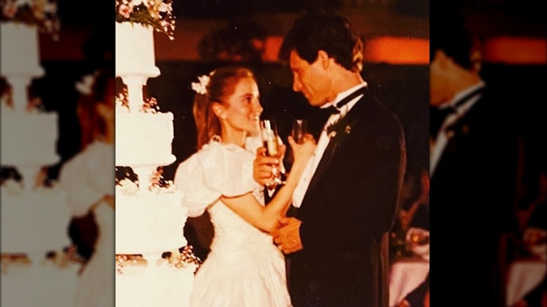 Maureen McCormick and Michael Cummings hold up glasses of champagne on their wedding day