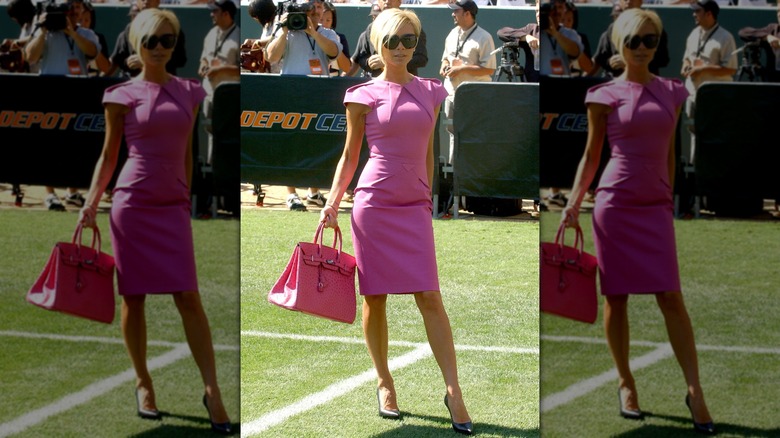 Victoria Beckham in a pink dress with a Hermes bag