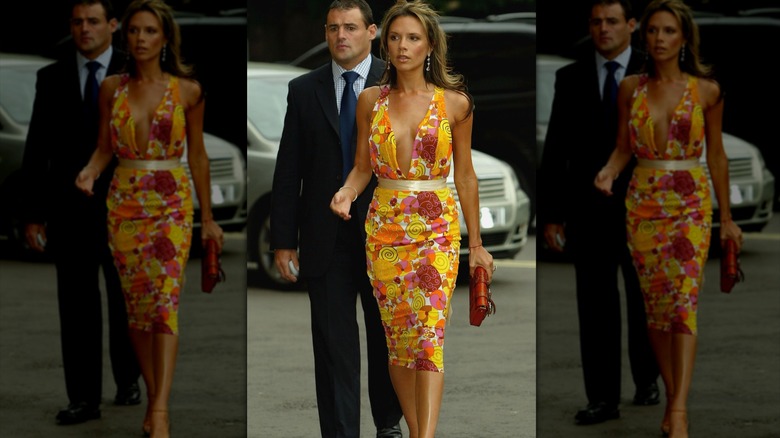 Victoria Beckham in a bright dress with a floral pattern