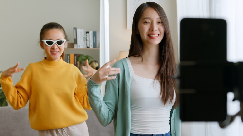 Two women filming TikTok fashion video
