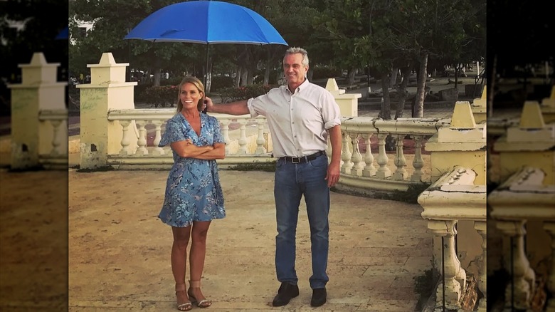 Cheryl Hines with Robert F. Kennedy Jr. holding an umbrella over her