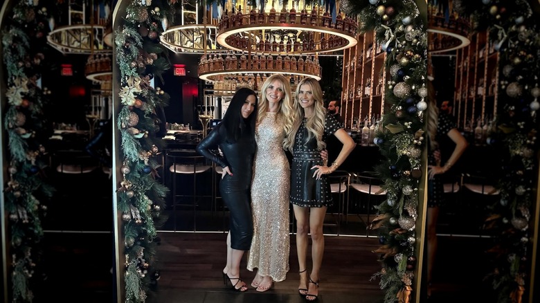 Christina Haack posing in a black minidress with friends