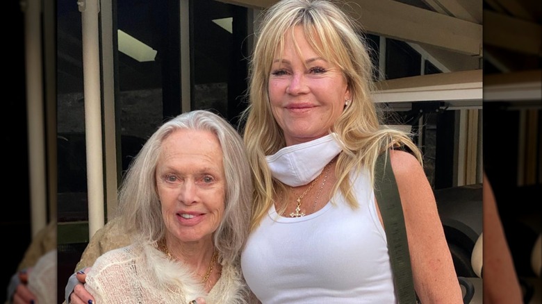 Melanie Griffith smiles with her arm wrapped around mother Tippi Hedren, who is sporting gray hair and a soft smile.
