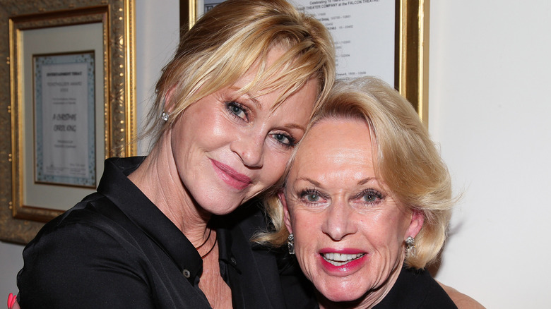 Melanie Griffith leans into her mother Tippi Hedren while both smiling for the camera