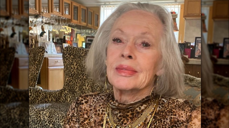 Tippi Hedren is photographed in an animal-print dress while sitting in a room with animal-print chairs in the background