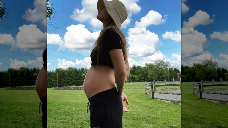 Gigi Hadid wearing a crop top showing off her baby bump