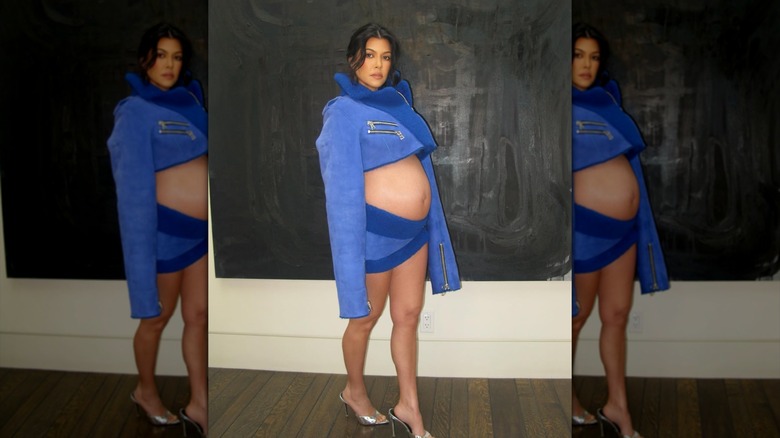 Kourtney Kardashian in a blue two-piece outfit that shows off her stomach