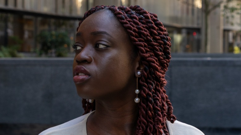 A woman wearing drop pearl earrings.