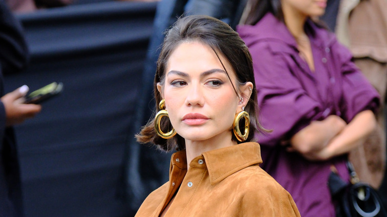 A woman with large bulky hoop earrings.