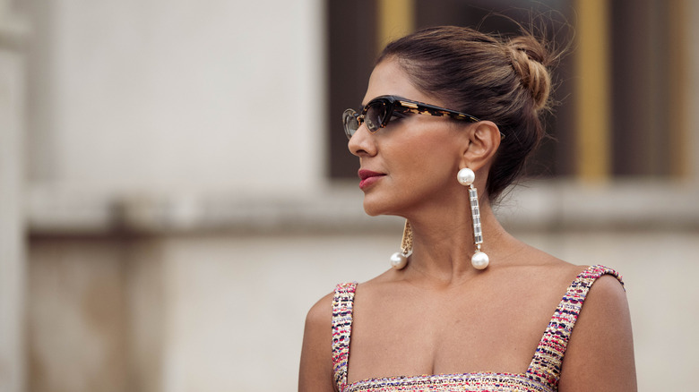 A woman with dangly pearl earrings