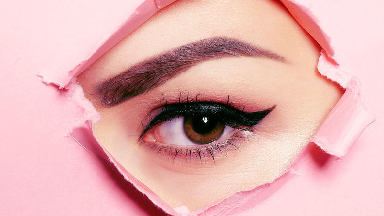 eyebrow black eyeliner pink background