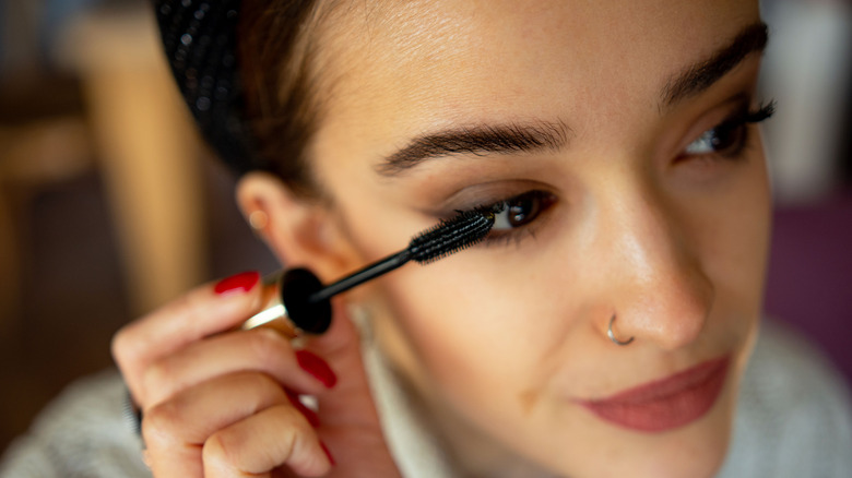 Woman applying mascara