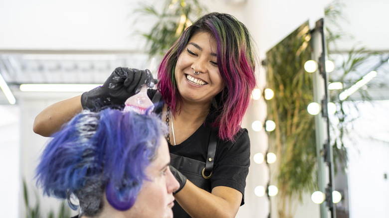 A stylist coloring hair