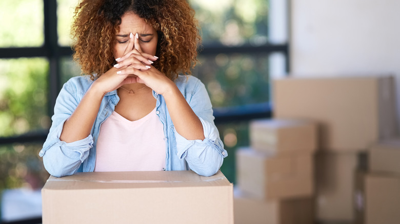 woman thinking with moving boxes
