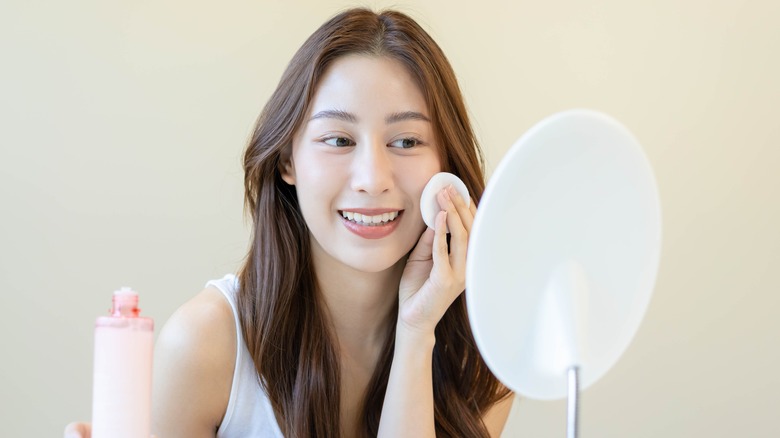 Woman looking in mirror, smiling