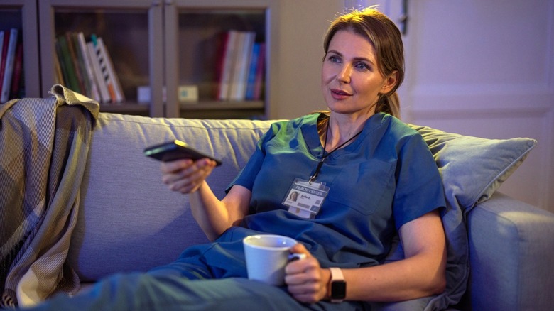 woman in scrubs on couch
