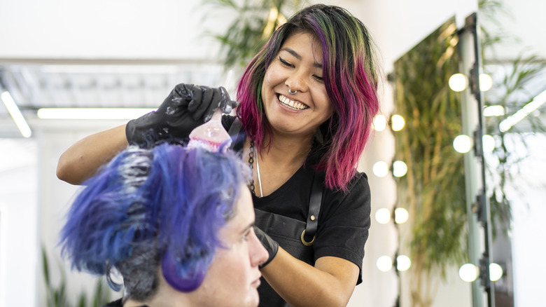 Hairdresser dyeing a client's hair 
