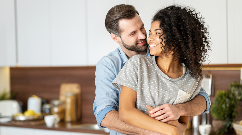 man holding woman from back