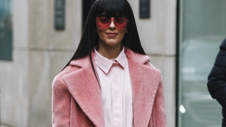 Woman walking in pink outfit and duster coat