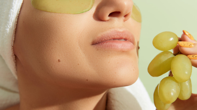 woman with grapes and eye patches