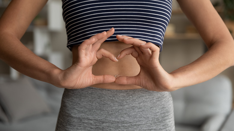 woman holding hands around stomach