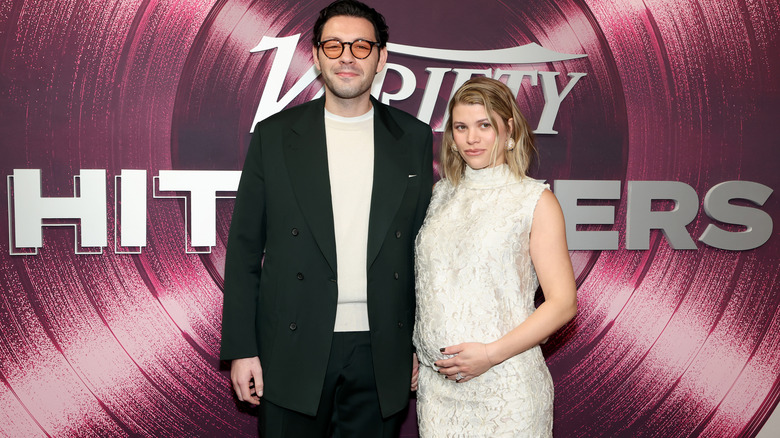 Sofia Riche in a white dress posing with her husband Elliot Grainge