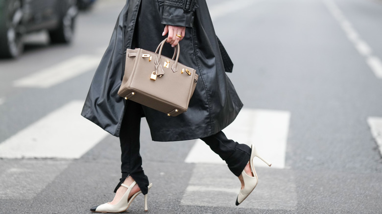 Person wearing leather trench, leggings, and pointed heels