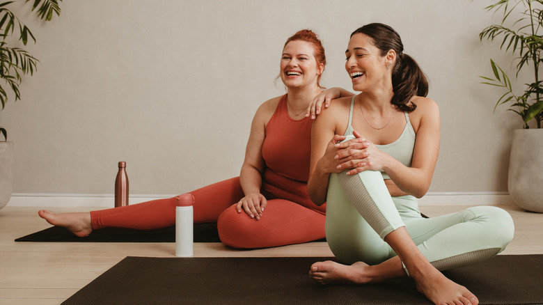 women sitting on yoga mats