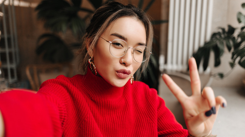 A woman taking as selfie while wearing glasses