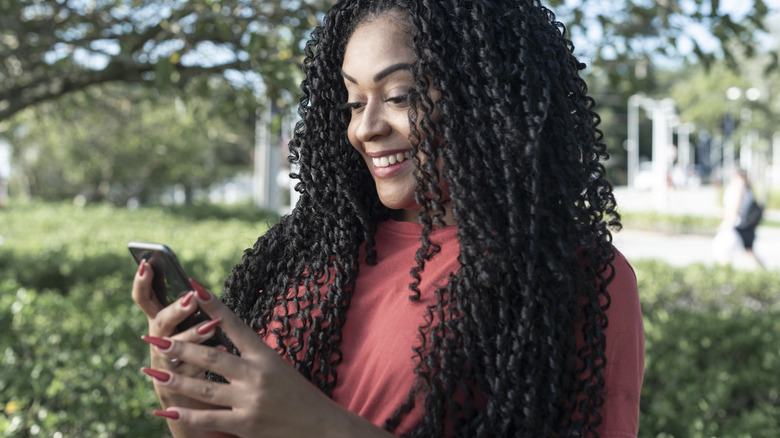 Woman with long nails using phone