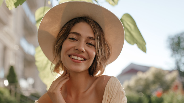 woman with healthy skin outdoors in hat