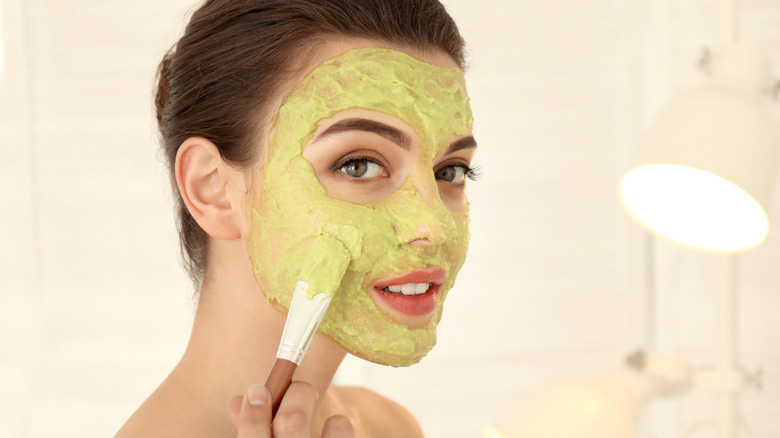 Woman applying face mask with a brush