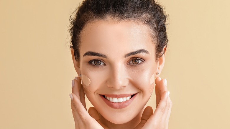 Woman applying foundation to her face