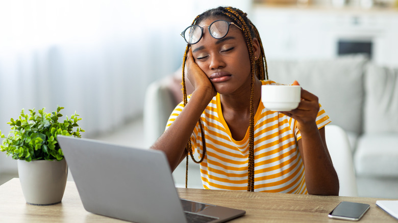 Tired woman asleep at laptop