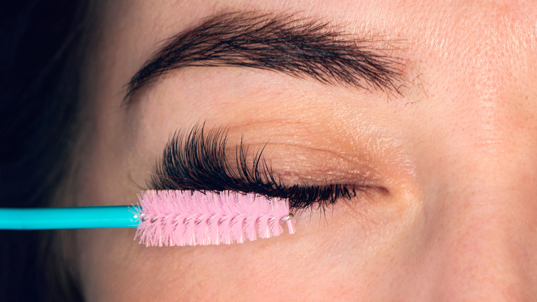 A woman brushing her eyelashes