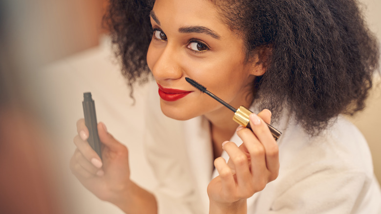 A woman applying mascara